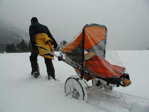 anstelle eines kinderwagens im tiefen schnee mit kindern wandern